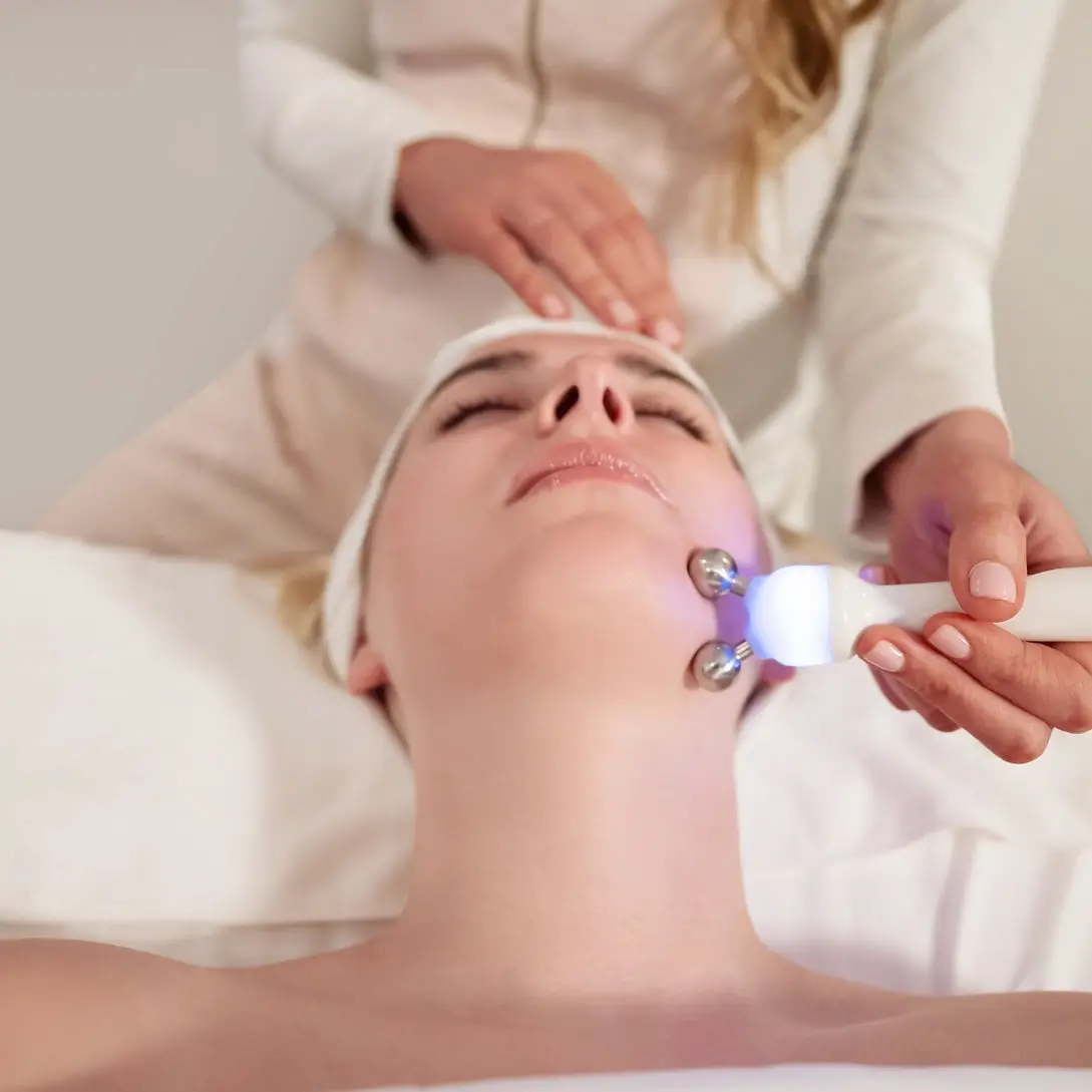 Woman receiving LED facial skin treatment at luxury spa and wellness clinic